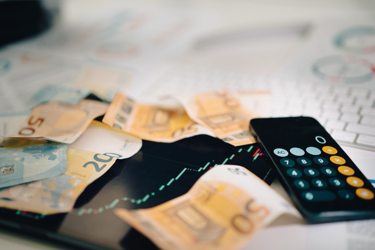 Banconote in Euro e grafici dell'andamento economico.