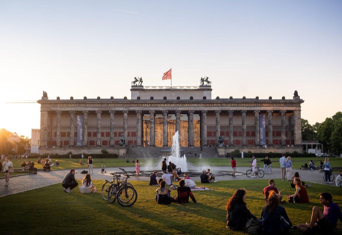 Muro di Berlino al sorgere del sole con persone in lontananza