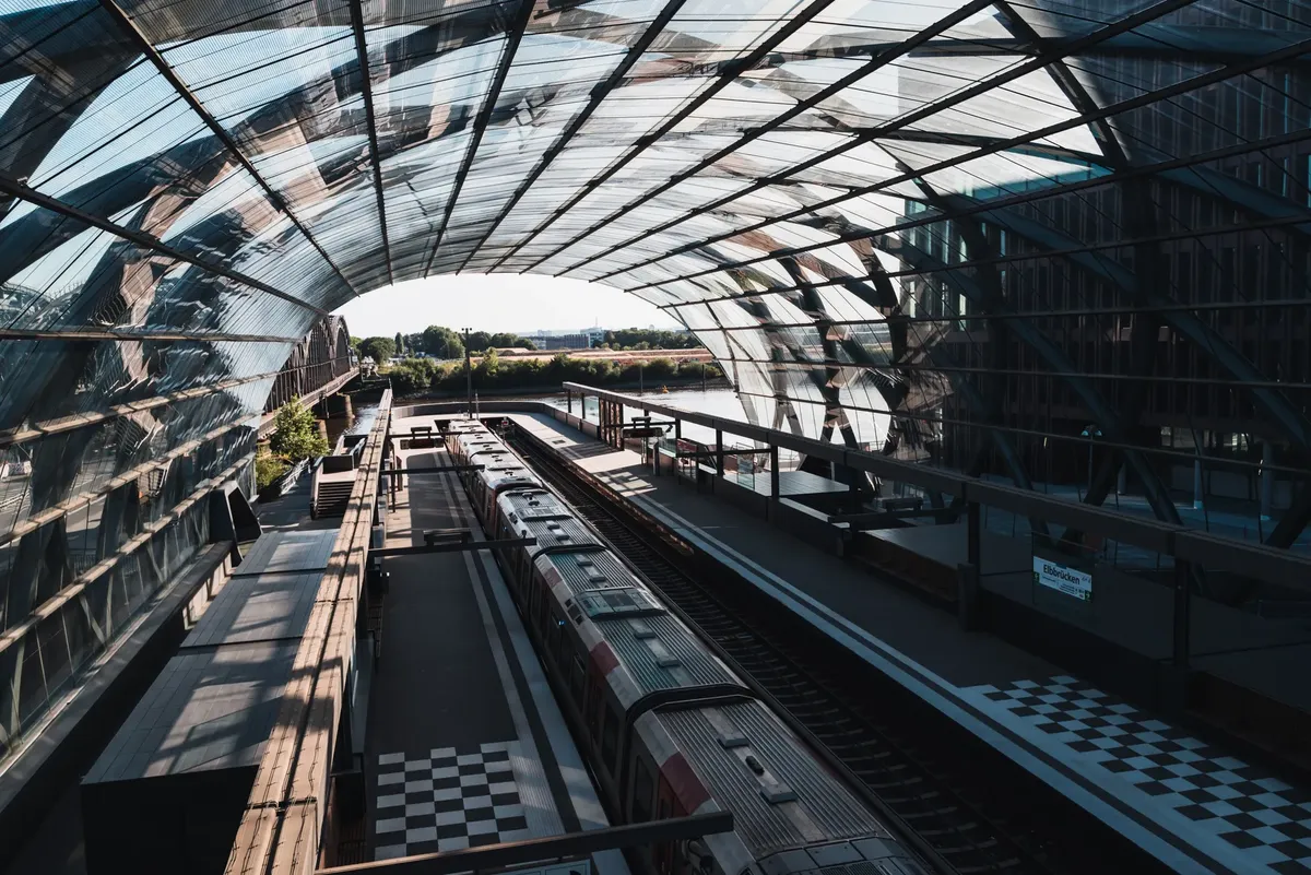 A modern, glass-covered train station in Hamburg, Germany, with a sleek architectural design.