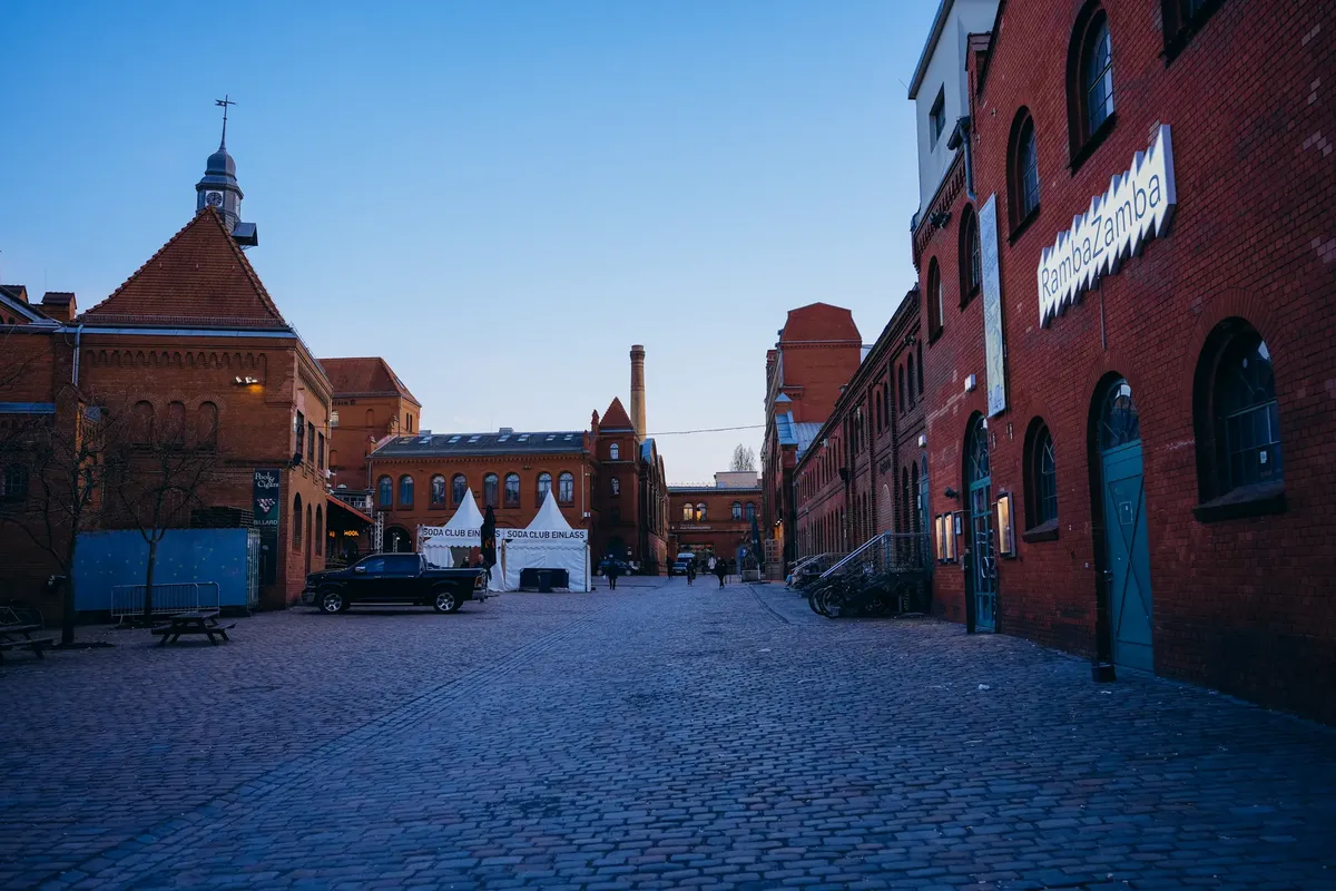 Charming view of a cobblestone street with historic brick buildings at dusk in Berlin, Germany.